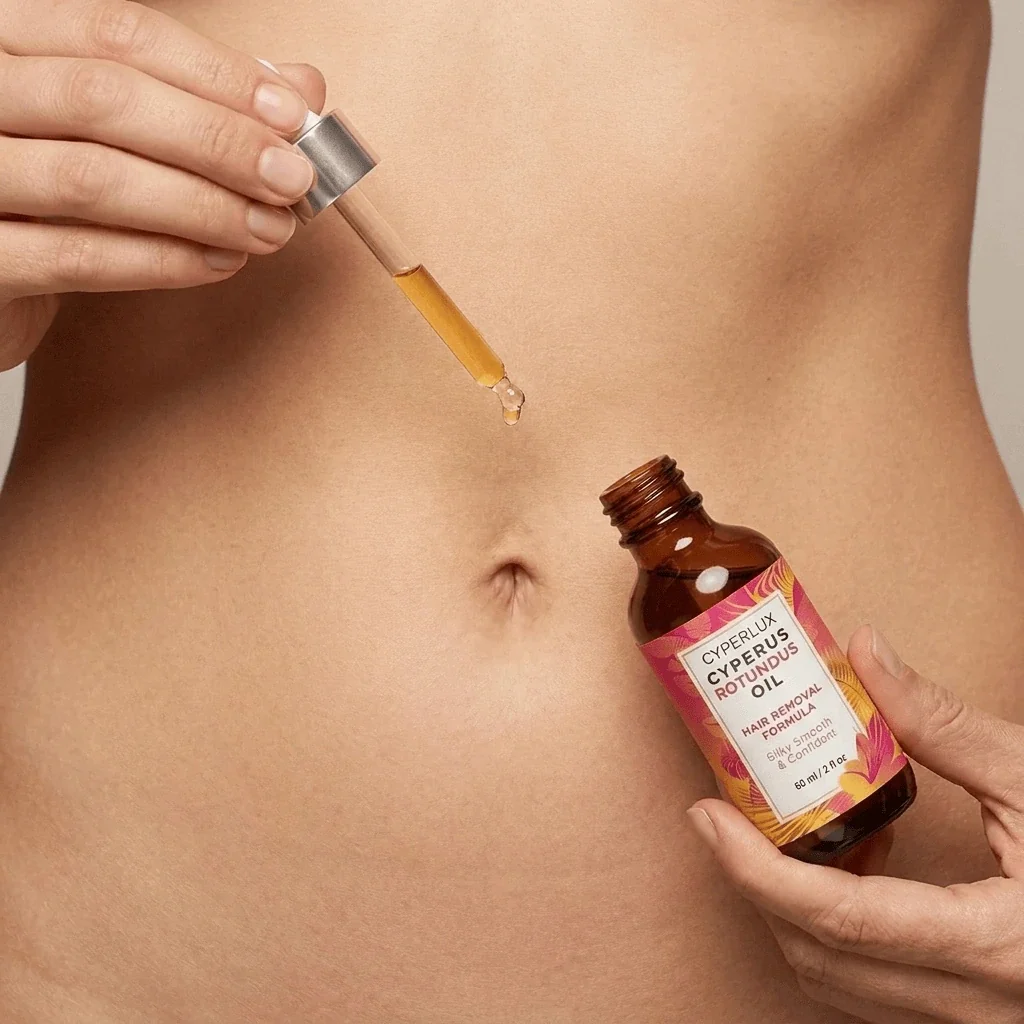 Drop of oil landing on skin, with open bottle in hand
